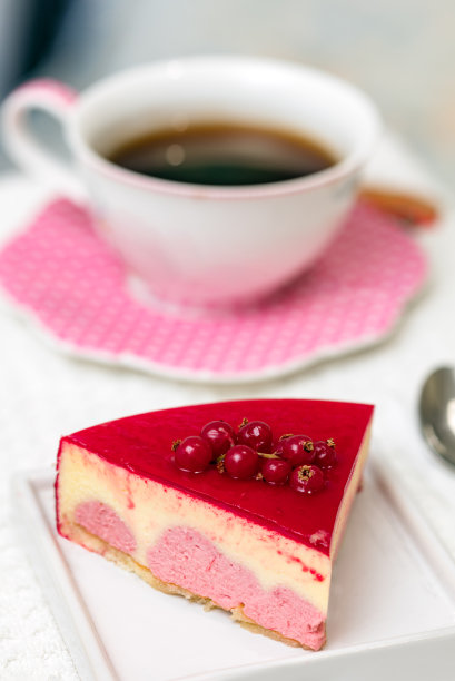 红莓和香草奶油蛋糕，以一杯茶和咖啡为背景。图片下载