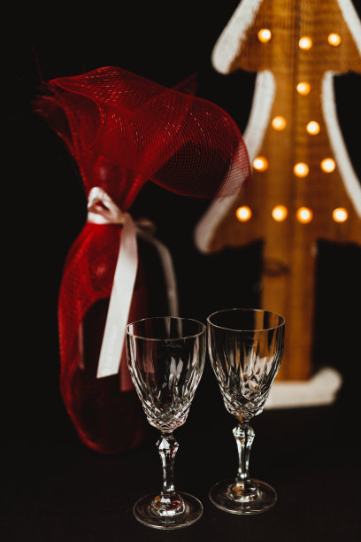 圣诞树旁放着水晶酒杯和酒瓶图片下载