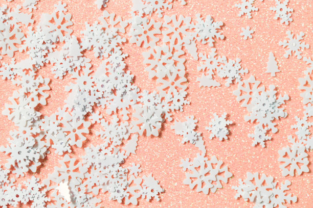 浅粉色背景与雪亮片和亮片。平的风格。冬天用雪花的柔软质感创造项目和设计图片下载