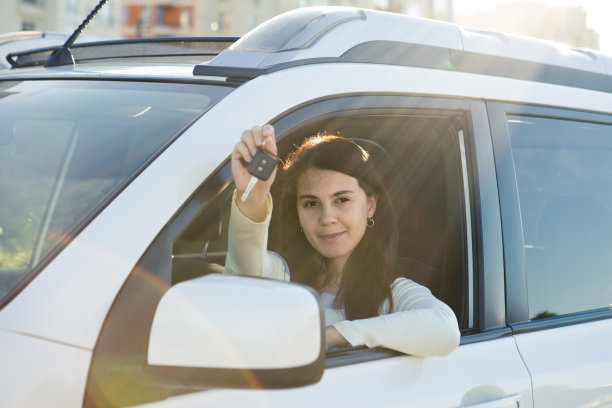 漂亮女人坐在车里，拿着钥匙图片下载