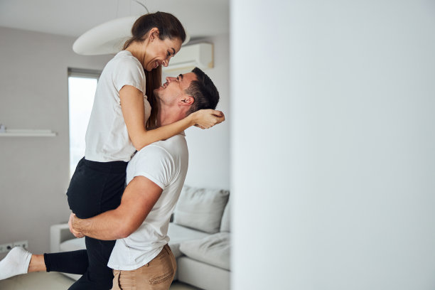 一对可爱的情侣在客厅里拥抱图片下载