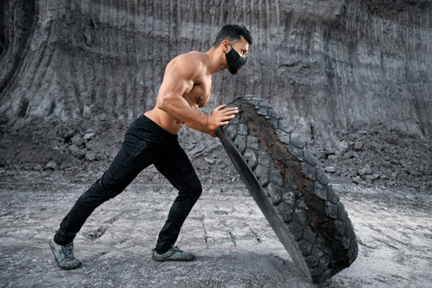 运动员戴着黑色面具在户外移动轮胎图片下载