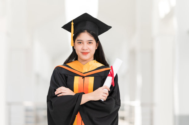 31、女大学毕业生戴着黑帽子，挂着黄流苏，在毕业的日子里面带微笑，开心无比图片下载