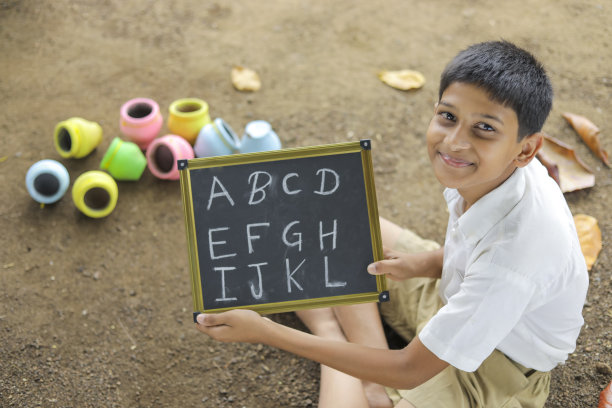 印度小孩在黑板上写字母图片下载