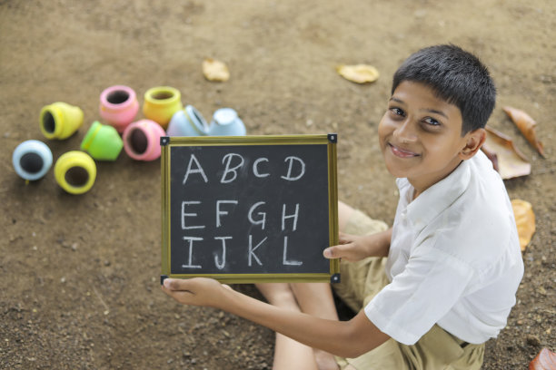 印度小孩在黑板上写字母图片下载