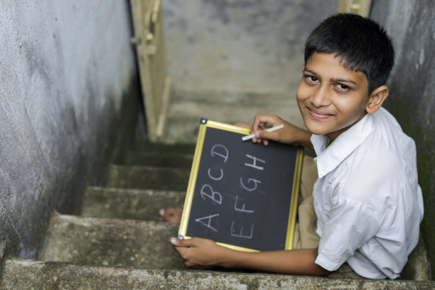 印度小孩在黑板上写字母图片下载