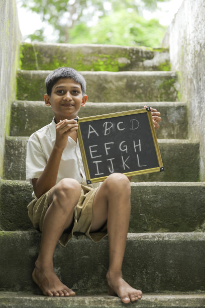 印度小孩在黑板上写字母图片下载