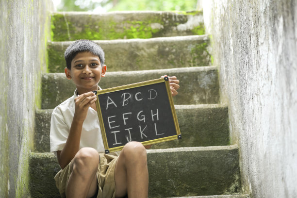 印度小孩在黑板上写字母图片下载
