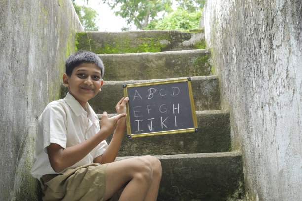 印度小孩在黑板上写字母图片下载