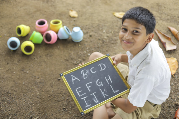 印度小孩在黑板上写字母图片下载