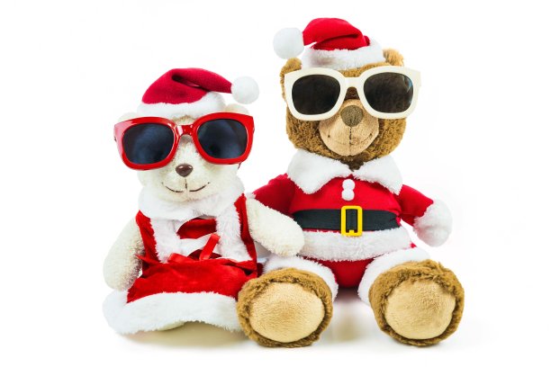 一对泰迪熊娃娃戴着圣诞老人集和眼镜孤立在白色的背景，圣诞节和新年的礼物图片下载