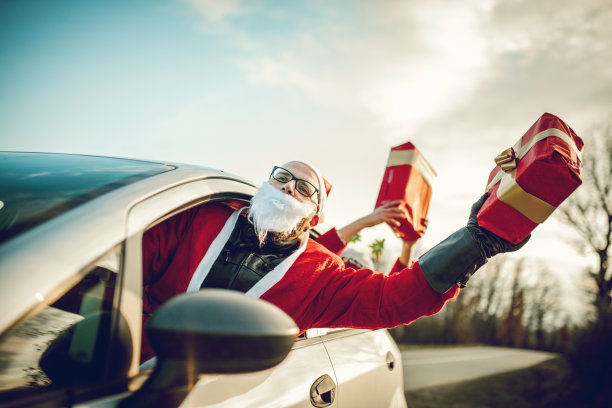 年轻的圣诞老人开车和他的女性朋友玩得开心图片下载