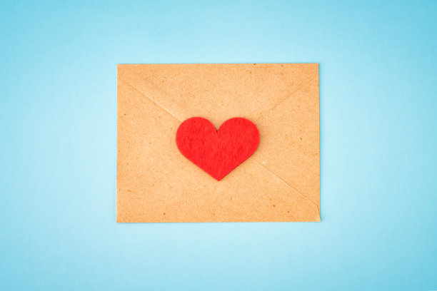 纸信封与空白的白色纸条模型里面和情人节的心在蓝色的背景图片下载