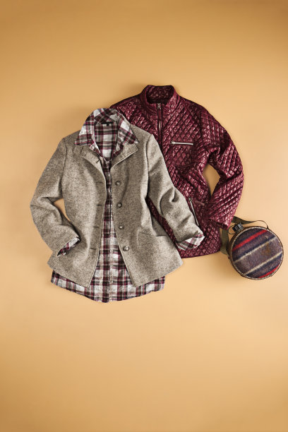 时髦的妇女把衣服孤立在棕色的背景上图片下载