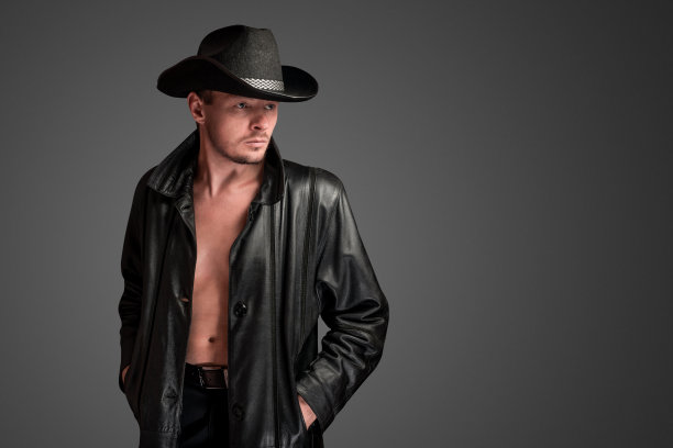 穿着皮夹克的牛仔看着他赤裸的身体。图片下载