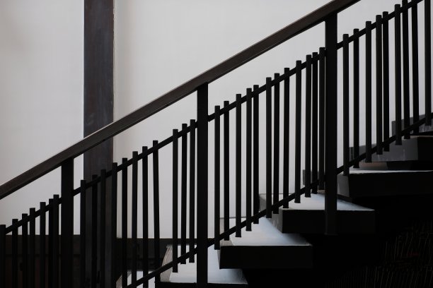 黑色栏杆的一边靠在白色的墙壁上图片下载