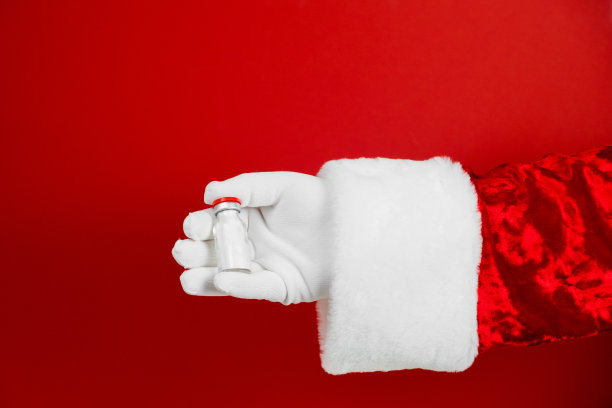 冠状病毒疫苗，covid -19疫苗接种。小瓶流感疫苗圣诞老人手拿一瓶解毒剂，注射药物。医学设备。液体药物或药物。医院医疗服务。冠状病毒疫苗，covid -19疫苗接种图片下载