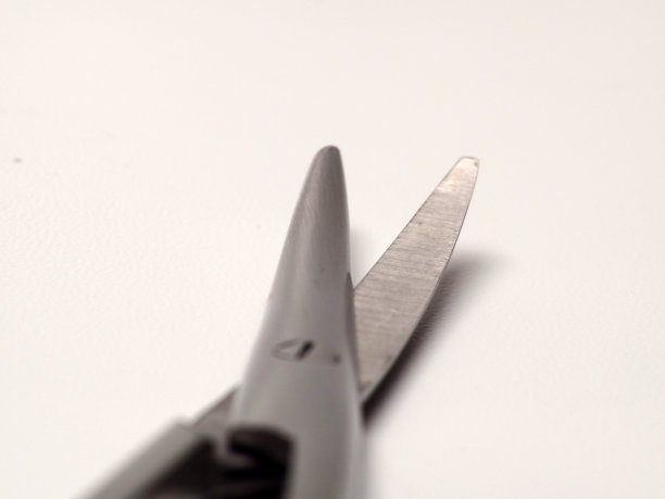 近距离拍摄的弯曲不锈钢医疗剪刀在一个孤立的白色背景图片下载