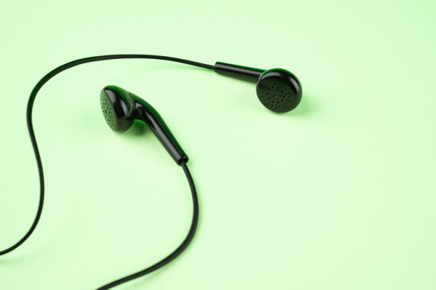 黑色耳机在绿色背景和拷贝空间。以上的观点。立体声音乐符号图片下载