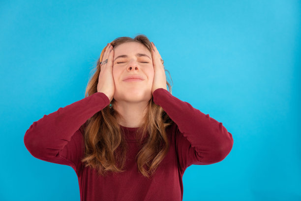 沮丧的少女在蓝色背景下双手抱头图片下载