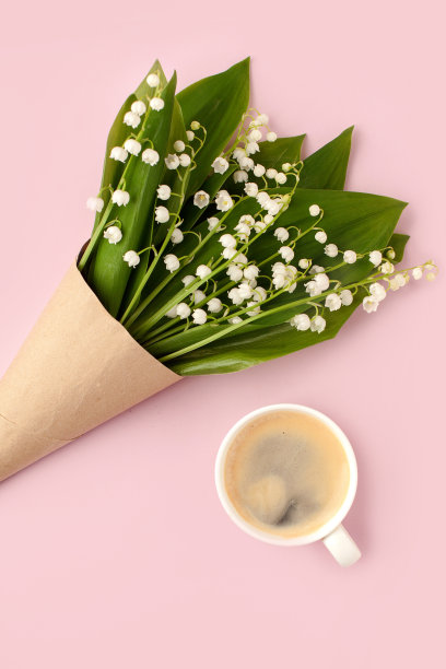 一束鲜花和一杯咖啡在粉红色的背景，复制空间，最小的浪漫贺卡为圣瓦伦丁，妈妈，妇女节，生日，浪漫的早餐概念图片下载