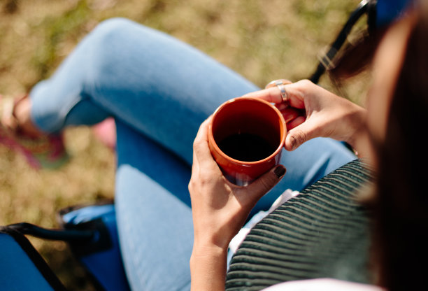 直接心爱的年轻女子手中的咖啡杯。图片下载