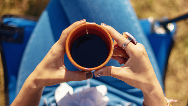 直接心爱的年轻女子手中的咖啡杯。图片下载