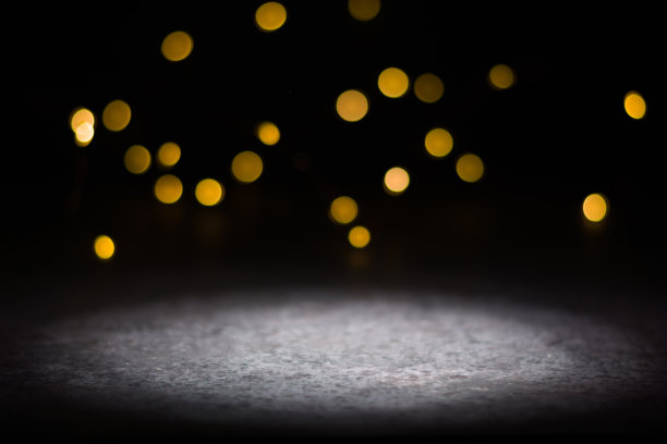 黑暗的背景和明亮模糊的灯光从背后。前景中被照亮的地方。图片下载