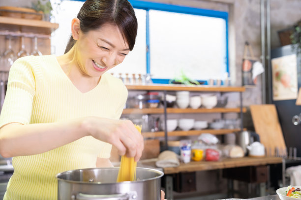 亚洲女人在厨房做饭，意大利面，图片下载