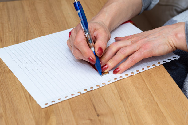 手握裁缝量尺和笔在纸上测量和描摹图片下载