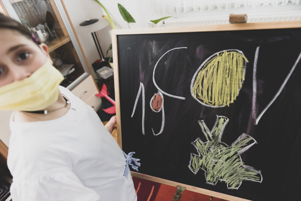 可爱的小女孩正在黑板上画画图片下载