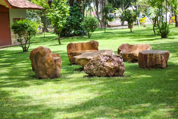 石头桌子和椅子上的绿色草地在花园室外的背景图片下载