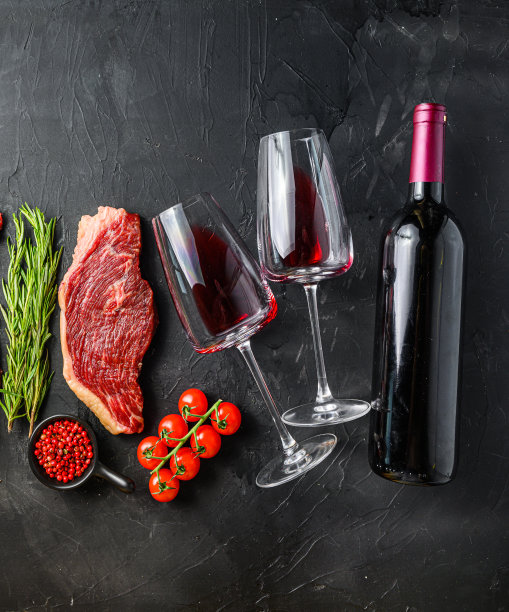 Picanha牛排与一瓶红酒和玻璃，俯视图在黑色纹理的背景。方形作物尺寸大。图片下载