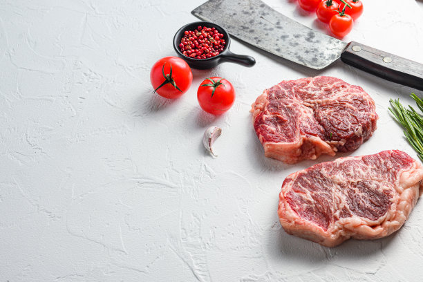 有机顶级牛排，生牛肉与调味料，迷迭香和切肉刀。白色纹理背景。带有文本空间的侧视图。图片下载