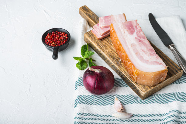 培根熏肉，切成薄片，与香草在白色的背景上，留出文字空间图片下载