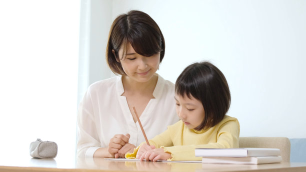年轻的亚洲女孩与母亲在家里学习图片下载