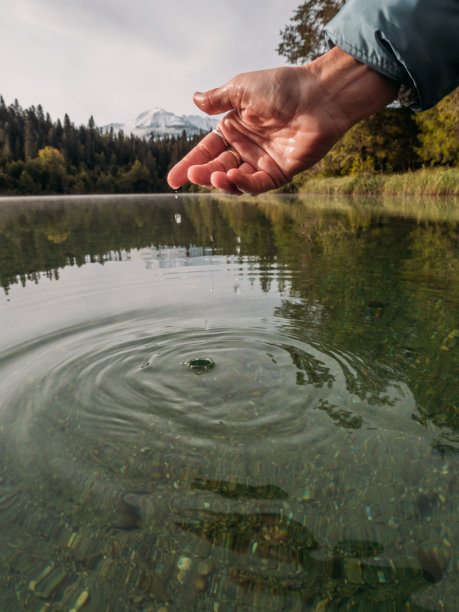 手从高山湖舀水图片下载