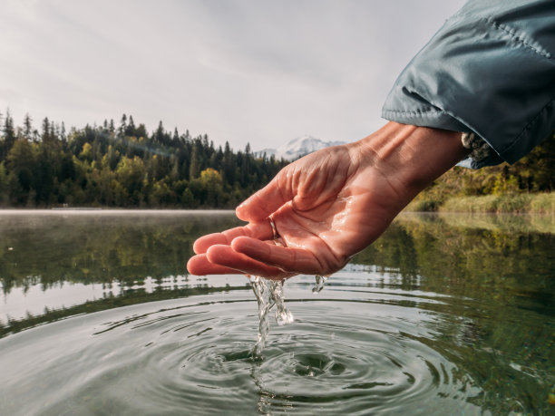 手从高山湖舀水图片下载