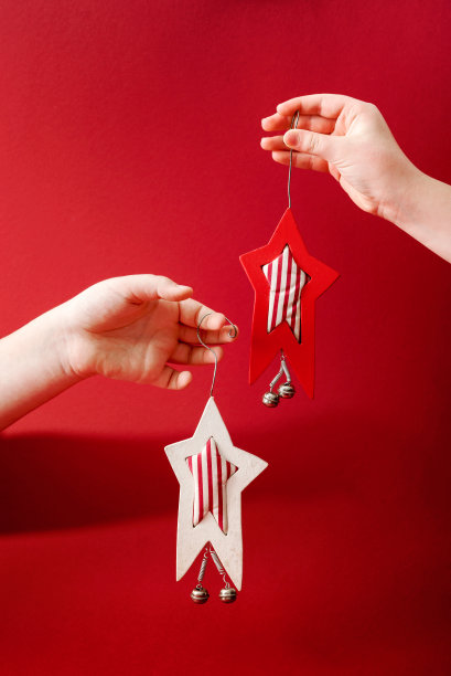 创意圣诞设计丰富的红色背景与手牵圣诞明星饰品。新年的概念。图片下载