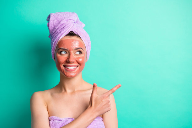 美丽微笑的人的照片看表明手指空白紫色毛巾孤立在绿松石色背景图片下载