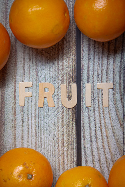 橘子水果周围的水果拼名字的木制字母单词图片下载