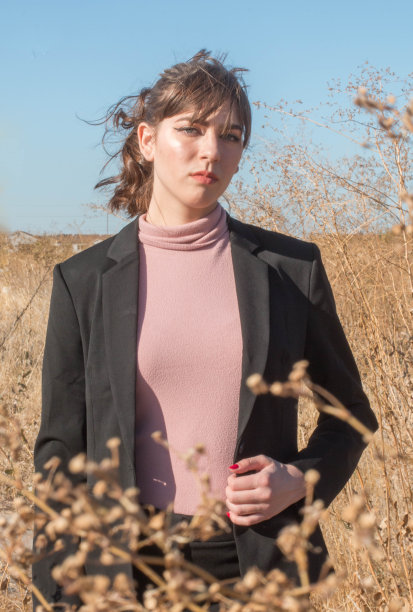 穿着运动夹克的女孩在野外看起来很严肃。图片下载