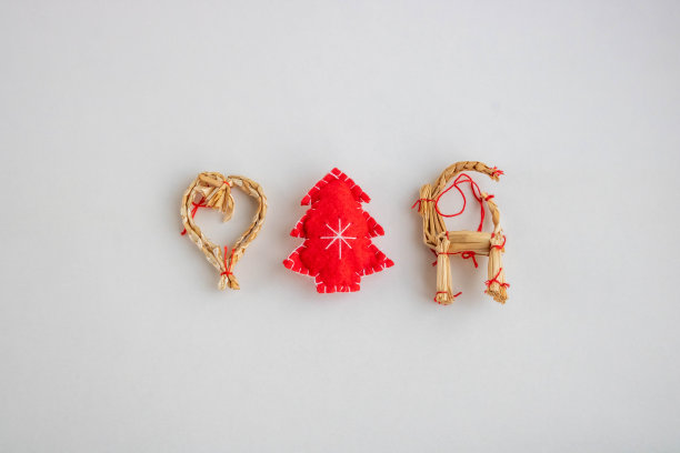 传统的稻草玩具和白色背景下的红色圣诞树图片下载