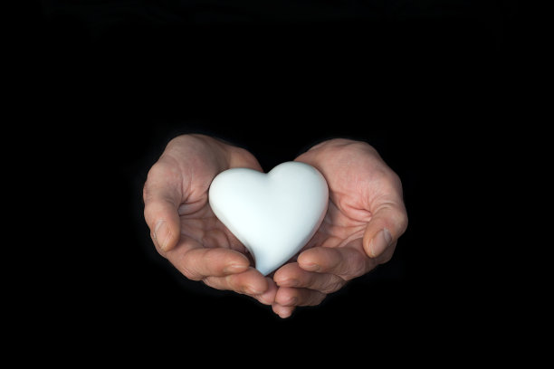 男性的手放在黑色的背景上，露出白色的手心。希望的力量，爱和奉献的力量。图片下载