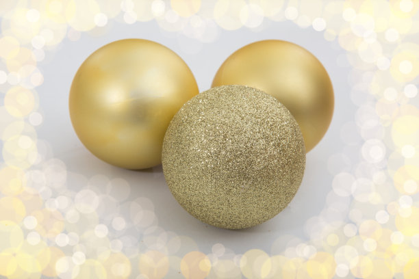 白色背景上的三个金色圣诞球图片下载
