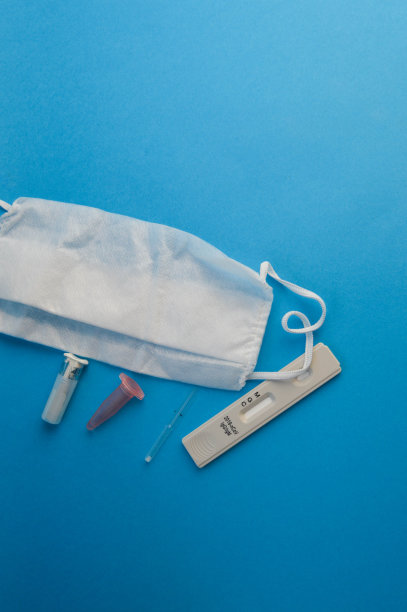 防护口罩或带冠状病毒试管试验的医用口罩，蓝色背景。冠状病毒或COVID-19防护概念图片下载