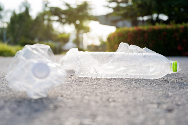 在公园里有塑料瓶和塑料袋。大量的塑料垃圾对大自然有害。图片下载