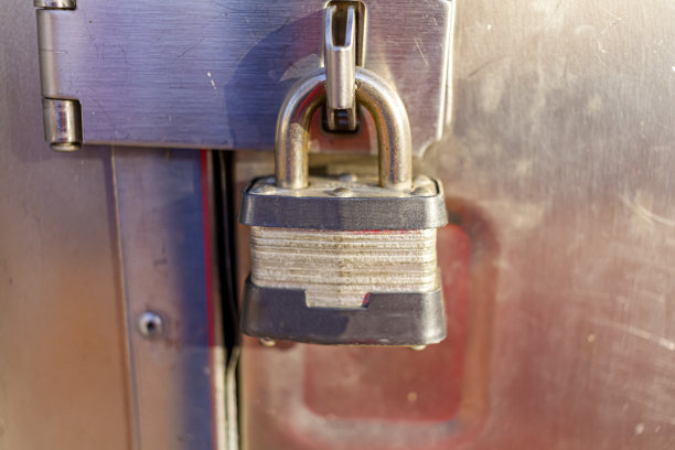 近距离孤立的图像铸铁粗糙纹理重型挂锁安全附加在铰链门上图片下载