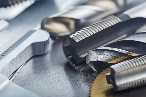 一套不同的钻头，螺纹丝锥和铣刀与游标卡尺钢板背景。锁匠工作协议。图片下载