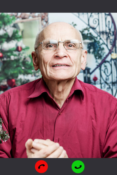 戴眼镜的老人用智能手机和家人视频聊天图片下载